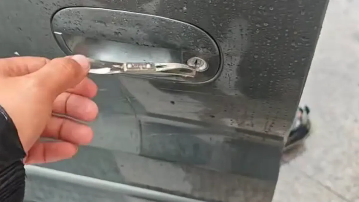 雨水中开锁师傅用工具开启汽车车门把手的实拍画面