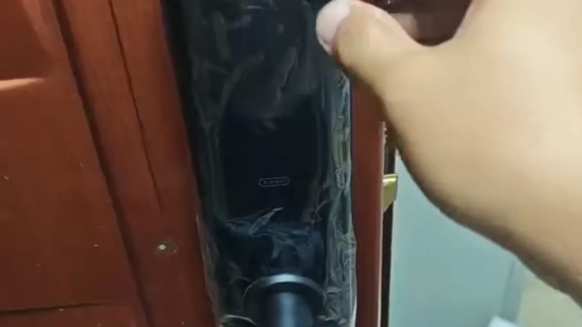 开锁师傅在住宅木门锁芯位置使用工具进行技术开启的作业实拍